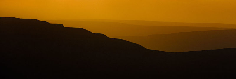 Scenic view of silhouette mountain against sky during sunset