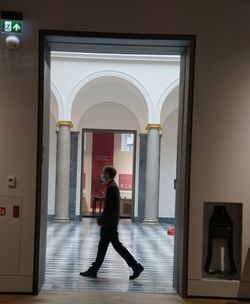 Side view of man walking in corridor of building