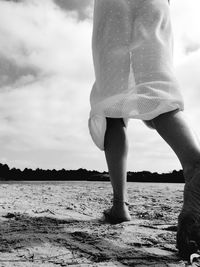 Low section of woman standing on beach