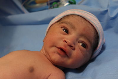 Close-up portrait of cute baby lying on bed