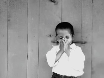 Portrait of boy standing against wall