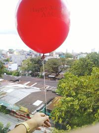 Red balloons against sky