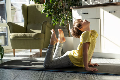 Little boy practicing yoga, stretching, fitness at home. distant. kids sport home quarantine.