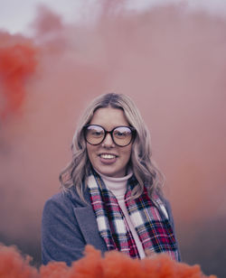 Portrait of young woman standing against yellow flower