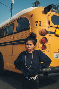 Portrait of woman standing against bus