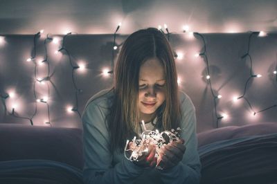 Young woman with illuminated lights at home