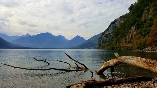 Scenic view of lake by mountains against sky