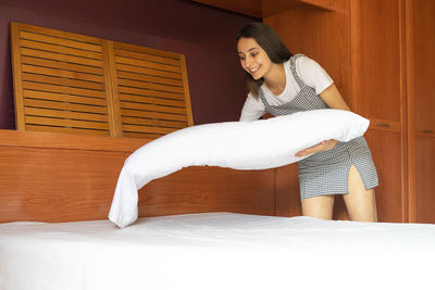 Woman standing on bed at home