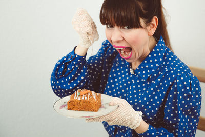 Mid adult woman eating sweet food at home