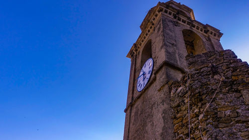 Low angle view of old building against blue sky