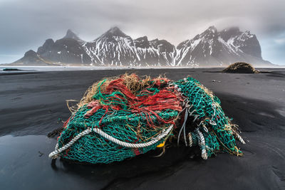 View of fishing net  on beach against mountains