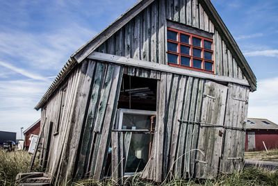 Exterior of old house on field against sky
