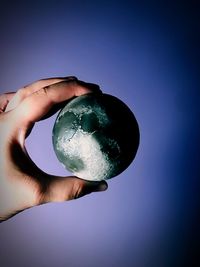 Close-up of hand holding blue sky