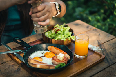 Midsection of woman sitting by breakfast