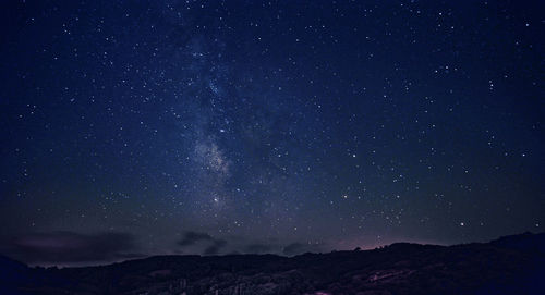 Scenic view of mountains against star field at night