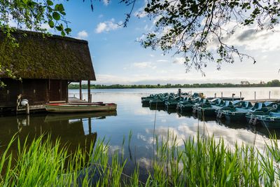 Scenic view of lake seeburger see against sky - boathouse and boats 