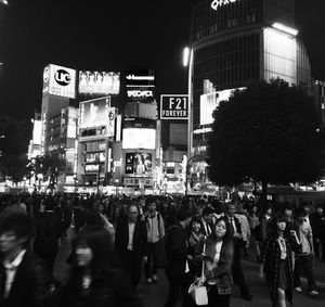 People walking on city street at night