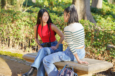 Side view of woman sitting on field