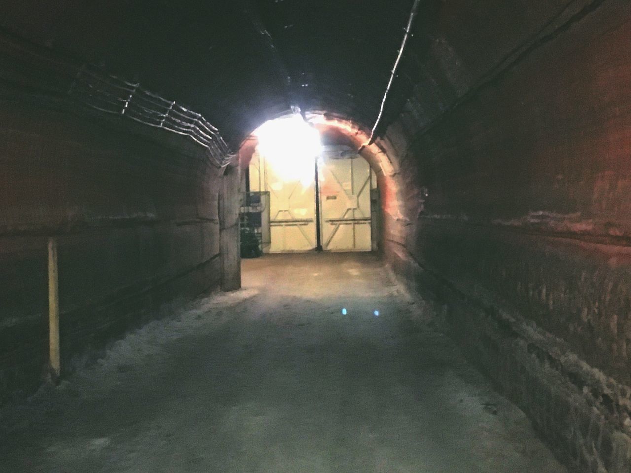 ILLUMINATED TUNNEL WITH BUILDING IN BACKGROUND