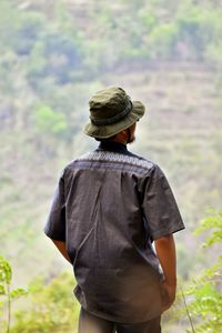 Rear view of man looking at camera