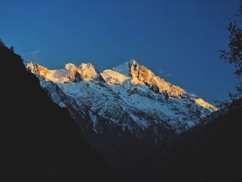 Scenic view of snowcapped mountains against clear blue sky