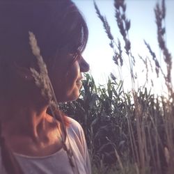 Close-up of young woman on field against sky