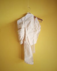 Close-up of ice cream hanging against yellow wall