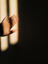 Close-up of hand touching shadow on wall