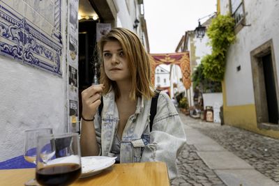 Close-up of woman eating food sitting at cafe outdoors