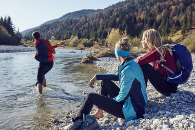 Group of friends hiking resting at the riverside