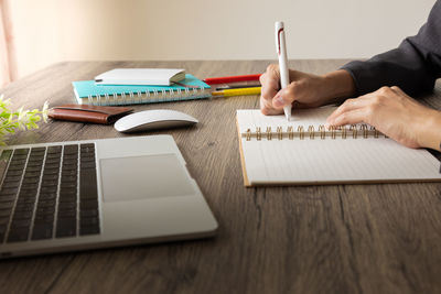 Midsection of man using mobile phone on table