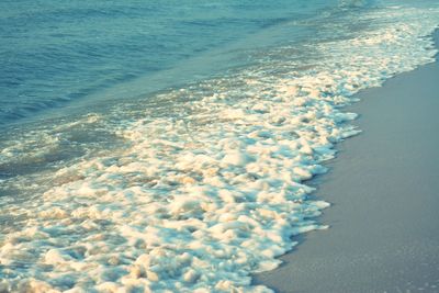 High angle view of waves rushing towards shore