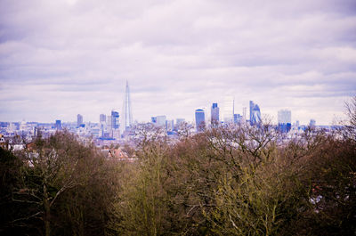 View of cityscape against cloudy sky