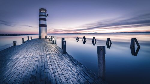 Lighthouse against sea at dusk