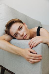 Portrait of young woman lying on bed at home