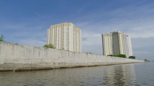 Sea by city against sky