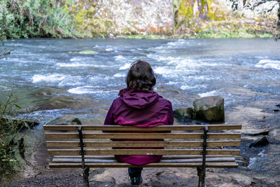 Rear view of woman sitting on bench