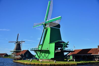 Low angle view of traditional windmill against blue sky