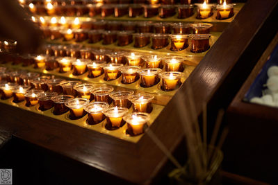 Illuminated candles on table in church
