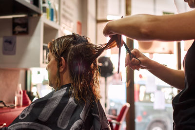 A close-up of a hairdresser cutting client's hair. small business