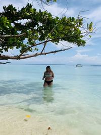 Woman in sea against sky