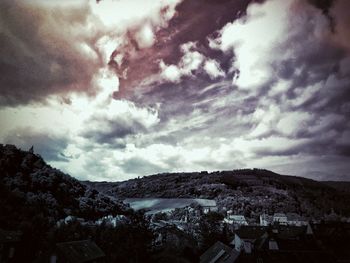 Aerial view of townscape by mountains against sky