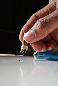 Close-up of hand holding cigarette