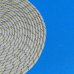 Close-up of rolled up rope against blue wall