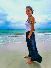 Full length of young woman standing on beach