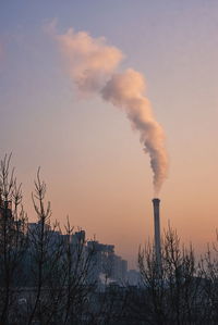 Smoke emitting from chimney against sky