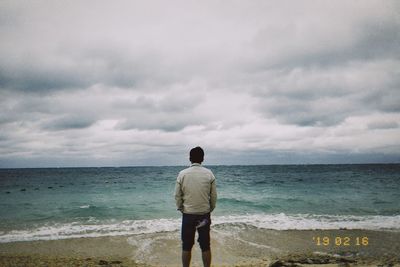 Rear view of man standing on beach