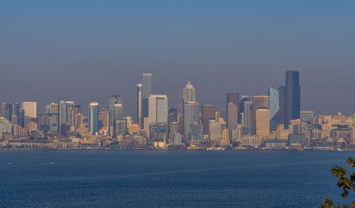 Illuminated buildings in city against clear sky