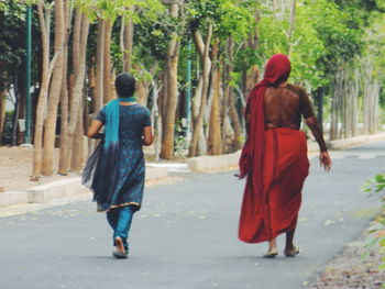 Rear view of people walking on road