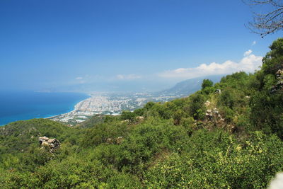 Scenic view of sea and mountains against blue sky